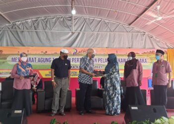 MAHDZIR Khalid (tiga dari kanan) menyampaikan sumbangan Yayasan Peladang peringkat kebangsaan dan dermasiswa kepada pelajar terpilih pada majlis perasmian Mesyuarat Agung Pertubuhan Peladang Kawasan Naka di Padang Terap hari ini.