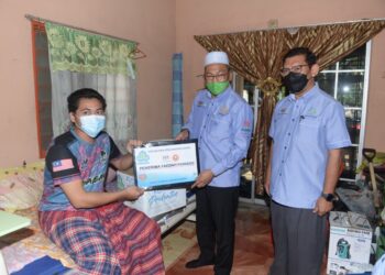 AWANG Hashim menyampaikan faedah hilang upaya Perkeso kepada Hussain Mohamad Danial di Kampung Sukamari, Pendang. - UTUSAN/MOHD. RAFIE AZIMI