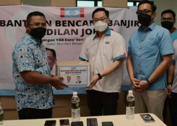 WEE Tse (tengah) menerima sumbangan bantuan Amirudin untuk diagihkan kepada mangsa banjir di negeri ini