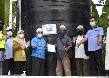 TUAN IBRAHIM Tuan Man (empat dari kiri) menyerahkan projek Wakaf Air kepada wakil penduduk di Felda Sungai Retang di Jerantut, Pahang.