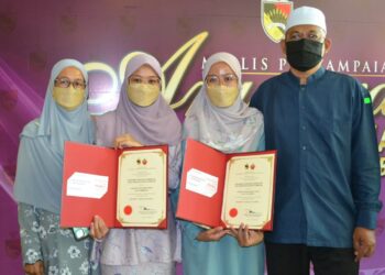 AQILAH Fatihah Rosli (dua dari kiri) dan Athirah Najihah Rosli (dua kanan) bersama bapa mereka, Rosli Ahmad dan ibu, Zarina Nusi pada majlis Anugerah Siswazah Cemerlang kelas pertama YNS Sesi I tahun 2020 yang diadakan di Seremban, hari ini. - UTUSAN/ZAKKINA WATI AHMAD TARMIZI