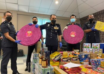 ABDUL Majid Mohd. Ali (tengah) menunjukkan mercun dan bunga api tanpa permit bernilai RM150,000 yang dirampas di Bukit Baru, Melaka. - UTUSAN/DIYANATUL ATIQAH ZAKARYA