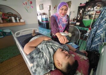 MOHAMAD Rashid Rusli yang hanya terlantar dibantu oleh ibunya, Norita Dualan. - UTUSAN/NURULAZMA SHAFIQAH KHAIRUL AZHAR