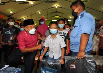 TOSRIN Jarvanthi merangkap Pengerusi Yayasan Sejahtera Kulai beramah mesra dengan sebahagian kanak-kanak yang menerima bantuan peralatan sekolah sempena Program Penyerahan Sumbangan ‘Back To School’ di Dewan Raya Putra, Bandar Putra, Kulai. - UTUSAN/RAJA JAAFAR ALI
