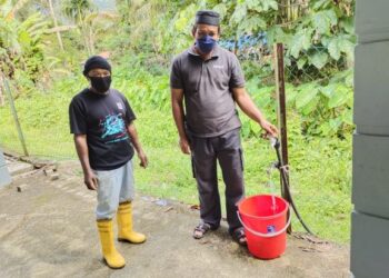 KAMARUZAM Mohd. Nor (kanan) dan Rusmah Buncit menunjukkan pili air di surau yang hanya mengalirkan air bukit untuk kegunaan penduduk di Rembau, Negeri Sembilan. – UTUSAN/NOR AINNA HAMZAH
