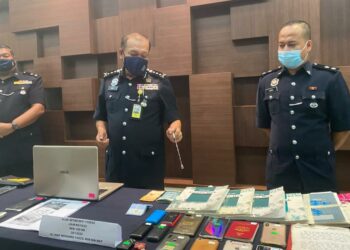 WAN Hassan Wan Ahmad (tengah) menunjukkan sebahagian barang kes yang dirampas dalam serbuan sindiket penipuan dalam talian pada sidang akhbar  di Alor Setar hari ini. - UTUSAN/NUR ANATI JUHARI