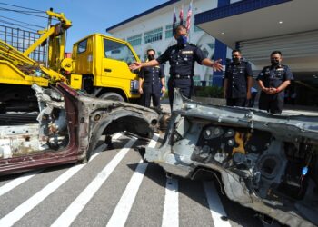 IBRAHIM Mat Som (dua dari kiri) menunjukkan bahagian badan kereta yang telah dipotong yang berjaya dirampas dengan tertangkapnya lima lelaki pada sidang akhbar di IPD Iskandar Puteri. - UTUSAN/RAJA JAAFAR ALI
