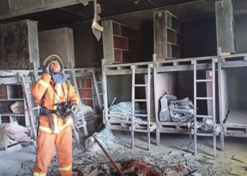 SEORANG anggota bomba memeriksa asrama Maahad Tahfiz Assyatirie cawangan Sungai Dedap, Yan yang terbakar hari ini.