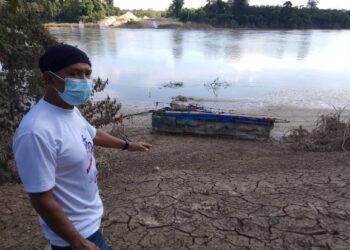 ABD. GHANI Abd. Malek menunjukkan keadaan sungai di Kampung Pangsenam yang dipenuhi selut dan lumpur. – UTUSAN/NORHAFIZAN ZULKIFLI