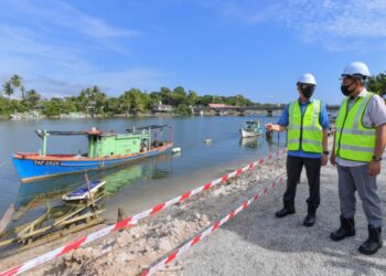 FADILLAH Yusof (kiri) dan Ahmad Samsuri Mokhtar melihat lokasi tapak projek naik taraf Jambatan Marang di Marang hari ini. - UTUSAN/PUQTRA HAIRRY ROSLI