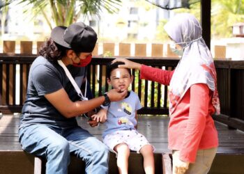 MOHD. Kairulnizam Ablah (kiri) bersama isterinya, Syazana Zakariah (kanan) melihat luka yang dialami anaknya selepas kejadian kemalangan langgar lembu ketika ditemui di Taman Jasin Bestari, Jasin, Melaka. - UTUSAN/RASUL AZLI SAMAD