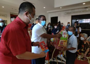 MUHAMMAD Sanusi Md. Nor menyampaikan hamper kepada salah seorang warga emas pada majlis penyampaian hamper sempena Tahun Baharu Cina di Alor Setar hari ini. - UTUSAN/ZAID MOHD. NOOR
