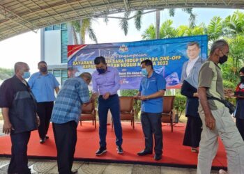 ABDUL RAZAK Abdul Rahman (tengah) menyampaikan bayaran Insentif Sara Hidup One- Off kepada 1,176 nelayan berdaftar di Batu Berendam, Melaka. - UTUSAN/DIYANATUL ATIQAH ZAKARYA