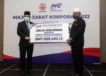 IDRIS Ahmad menerima replika cek zakat perniagaan daripada Abdul Hakim Amir Osman (kiri) pada Majlis Zakat Korporat 2022 di Putrajaya.- UTUSAN/FAISOL MUSTAFA