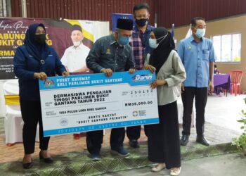 SYED Abu Hussin Hafiz Syed Abdul Fasal (tengah) menyampaikan cek kepada penerima dalam program penyampaian Buku Akaun Tabung Anak Bukit Gantang di Bukit Gantang hari ini. - UTUSAN/WAT KAMAL ABAS