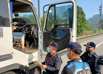 BAKRI Zainal Abidin ketika menjalankan pemeriksaan terhadap muatan berat yang didapati menggunakan jalan raya ketika waktu larangan di Lebuhraya Lembah Klang Baru (NKVE) hari ini.