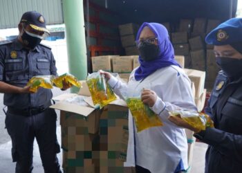 AIN Arjuna Aziz Zaman (tengah) menunjukkan minyak masak paket yang dirampas dalam satu serbuan di sebuah premis di Bukit Pelandok, Port Dickson semalam.