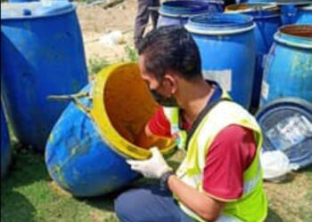 PEGAWAI JAS memeriksa tong dram yang ditemukan menyebabkan longkang Jalan Syed Osman Idid, Sungai Petani, Kedah menjadi warna hijau. - JAS