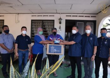 DAVID Wong (tiga dari kanan) menyampaikan kurniaan peribadi dan sumbangan makanan daripada Sultan Johor kepada Mohd. Izwan Syah Ismail di Pontian, Johor.
