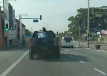 TANGKAP layar daripada video menunjukkan dua kanak-kanak berdiri di belakang tempat muatan belakang sebuah pacuan empat roda dipercayai berlaku di sebuah daerah di Kedah. - MEDIA SOSIAL