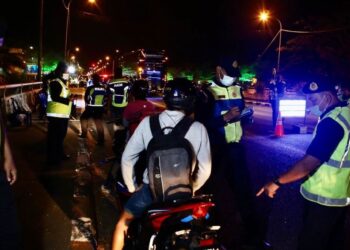 ANGGOTA JPJ memeriksa motosikal yang ditahan Op Khas Motosikal Tahun Baharu Cina di Kepala Batas, Jitra malam tadi. - UTUSAN/SHAHIR NOORDIN