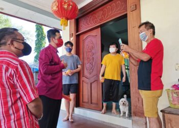 ALIAKBAR Gulasan (dua kiri) mengagihkan limau Mandarin kepada komuniti Cina di Inanam, Kota Kinabalu hari ini.