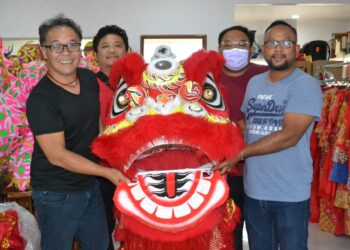 ROSMAN Mohamad (kanan) bersama Soh Ban Choon (kiri) menunjukkan kostum tarian singa yang telah ditaja Rosman di Lukut, Port Dickson. -UTUSAN/ZAKKINA WATI AHMAD TARMIZI