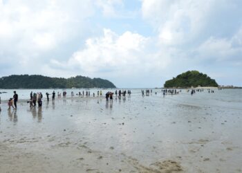 PENGUNJUNG berjalan kaki dari Pantai Teluk Nipah ke Pulau Giam sejauh kira-kira 400 meter ketika fenomena air laut surut di Pulau Pangkor semalam. - UTUSAN/ZULFACHRI ZULKIFLI