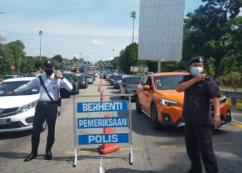 ANGGOTA polis memeriksa kenderaan yang masuk ke Melaka melalui Plaza Tol Ayer Keroh, Melaka. - UTUSAN/DIYANATUL ATIQAH ZAKARYA