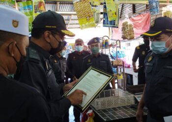 AZMAN  Ahmad (dua dari kiri) melihat lesen niaga salah seorang peniaga ketika Program Pemeriksaan dan Pemantauan Premis di Kawasan Luar Bandar di Kampung Lalang, Mukim Siong, Baling hari ini.