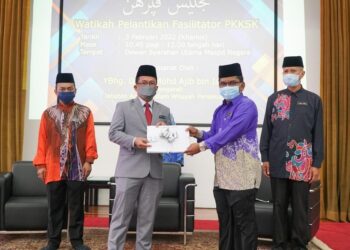 MOHD. Ajib Ismail (dua dari kiri) menyerahkan surat pelantikan kepada salah seorang Fasilitator PKKSK, di Kuala Lumpur. - JAWI
