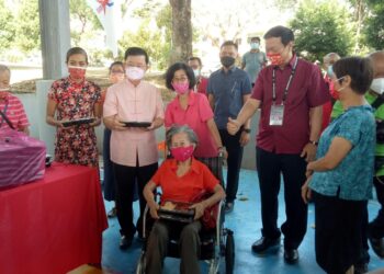 CHOW Kon Yeow (tiga dari kiri) mengedarkan bungkusan makanan kepada penduduk di Taman Island Glades, Jelutong, Pulau Pinang sempena Tahun Baharu Cina hari ini.