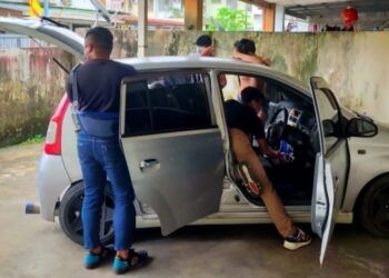 ANGGOTA polis berpakaian preman menggeledah sebuah kenderaan ketika serbuan di sebuah kediaman, di Kuching.