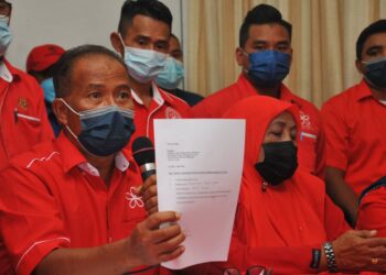 MUSA Khamis (kiri) menunjukkan surat ikrar setia ahli Bersatu pada sidang akhbar di Rumah Bersatu Pontian. UTUSAN/RAJA JAAFAR ALI