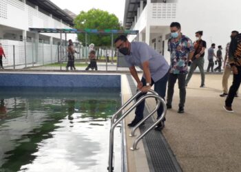 AHMAD Faizal Azumu melihat keadaan kolam ketika hadir pada Majlis Penyerahan Siap Projek Naik Taraf dan Baik Pulih KRMSAU di Bandar Penawar, Kota Tinggi.