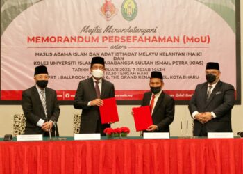 ZULKIFLE Ab. Rahman (dua dari kiri) bertukar dokumen dengan Ab. Aziz Mohd. Zin selepas menandatangani MoU membabitkan kerjasama Maik dengan KIAS di Kota Bharu semalam. - UTUSAN/ZULHANIFA SIDEK
