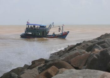 ANTARA bot nelayan yang keluar ke laut dalam keadaan cuaca tidak menentu di muara Sungai Terengganu di Kuala Terengganu. - PUQTRA HAIRRY ROSLI