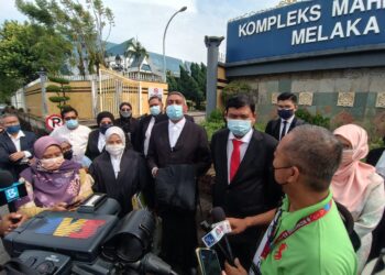MOHAMAD ALI Mohamad (tali leher merah) bersama barisan peguamnya bercakap kepada pemberita di luar Kompleks Mahkamah Ayer Keroh, Melaka. - UTUSAN/DIYANATUL ATIQAH ZAKARYA