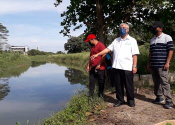 HASSAN Abdul Karim (tengah) meninjau keadaan Sungai Masai yang sering berlaku banjir kilat di Kampung Desa Bakti, Pasir Gudang, Johor.