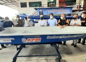 SULAIMAN Md. Ali (enam dari kanan) menyerahkan surat penyerahan sebuah bot untuk membantu mangsa banjir kepada wakil Angkatan Pertahanan Awam (APM) Melaka di kilang Seafarer Explorer di Pulau Gadong, Melaka. - UTUSAN/AMRAN MULUP