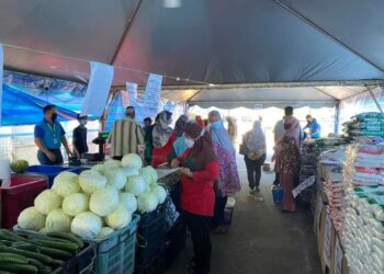 PENGGUNA memilih barang keperluan dapur di khemah Program Jualan Keluarga Malaysia di hadapan Pasar Raya TF bandar Inderapura di Jerantut, Pahang. - UTUSAN/HARIS FADILAH AHMAD
