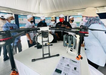 MUHAMMAD Sanusi Md Nor (tengah) mendengar penerangan pihak penganjur mengenai pelaksanaan projek EMM 2.0 Pendang di Kampung Asam Jawa, Pendang hari ini. - UTUSAN/JAMLIAH ABDULLAH