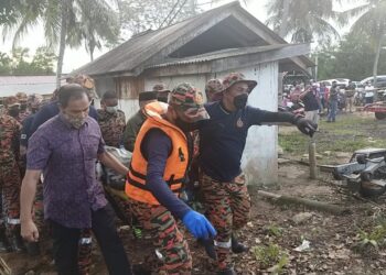 BOMBA mengusung mayat Shukri Wahab yang ditemukan tersangkut pada pukat selepas mangsa terjunam dalam Sungai Keluang Besar di Besut, hari ini.