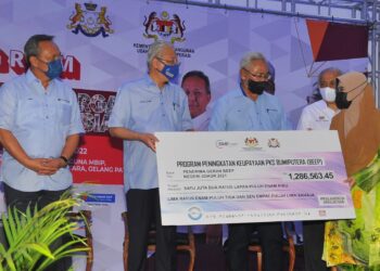 ISMAIL Sabri Yaakob menyampaikan replika cek kepada usahawan sambil diperhatikan Hasni Mohamad dan Noh Omar sempena Karnival Usahawan dan Koperasi Keluarga Malaysia di Dewan MBIP Taman Nusantara, Iskandar Puteri. -UTUSAN/RAJA JAAFAR ALI