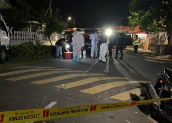ANGGOTA polis dan kesihatan memakai peralatan perlindungan diri (PPE) memandangkan salah seorang si mati disahkan positif Covid-19. - UTUSAN/DIYANATUL ATIQAH ZAKARYA
