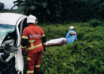 MANGSA maut di lokasi kejadian selepas kenderaannya bertembung lori treler di Jalan Kampung Serusup, Tuaran, pagi tadi. - IHSAN BOMBA