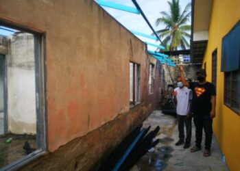 MOHD. Nizam Mohd. Sharip (kanan) bersama bapanya Mohd. Sharip Sulong menunjukkan hanya rangka bumbung sahaja dibaiki di tapak rumah yang terbakar di Jalan Kapar di Klang, Selangor. - UTUSAN/ABDUL RAZAK IDRIS