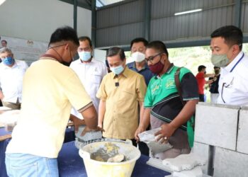 WEE Jeck Seng (tengah) melihat binaan yang diperbuat daripada pokok selepas melakukan majlis pecah tanah Surau An-Nur di Kampung Melayu Bukit Panjang, Pekan Nanas, di Pontian.