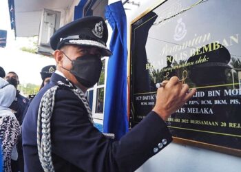 ABDUL Majid Mohd. Ali menandatangani plak perasmian Balai Polis Bemban, Jasin, Melaka. - UTUSAN/DIYANATUL ATIQAH ZAKARYA