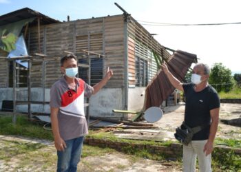 HAM Lock Heng (kanan) bersama Lie Show Heng menujukkan rumahnya yang mengalami kerosakan di bahagian bumbung selepas atap rumahnya runtuh dan diterbangkan angin ribut dalam kejadian di Kampung Baru Rahang, Seremban. -UTUSAN/ZAKKINA WATI AHMAD TARMIZI